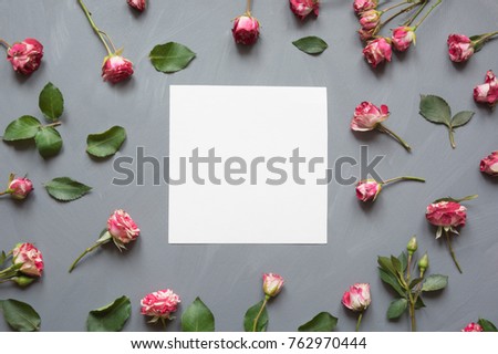 Floral pattern made of pink bush roses, white blank, green leaves on gray background.Valentine's background.