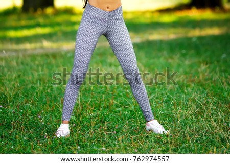 Beautiful sport fitness girl in sportswear doing fitness exercise in the park.