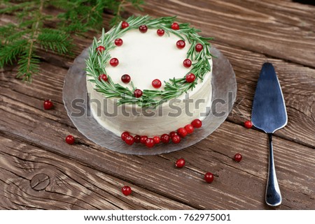 White cake decorated with rosemary and cranberries