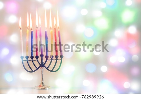 Image of jewish holiday Hanukkah on happy colorful background with menorah (traditional candelabra) and burning candles.