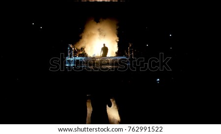 Fighter in dark comes to ring and smoke. Background fans, MMA. Fighter presentation before fight. Shadow of fighter and smoke with lights