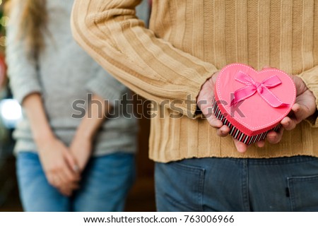 couple in love celebrate valentine's day. Man making surprise on holiday to his pretty wife. Wife close her eyes and waiting for present. Concept of happy valentine's day Royalty-Free Stock Photo #763006966