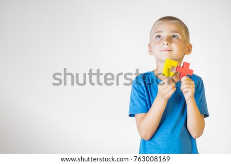 Boy with wooden logical toy. Child playing educational toys.
