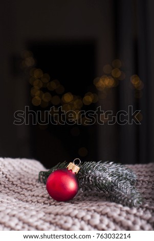 Red Christmas ball near Christmas tree branch on blur background of New Year Tree. New year Theme. Christmas Time. Vintage photo