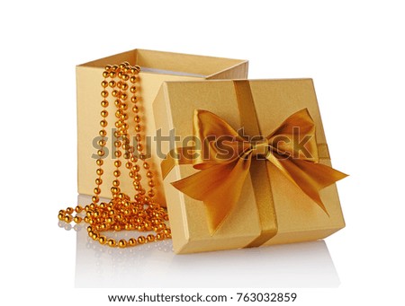 Golden classic shiny open gift box with gold satin bow and beads isolated on white background