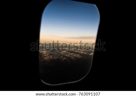 Photo of mountains through an airplane window
