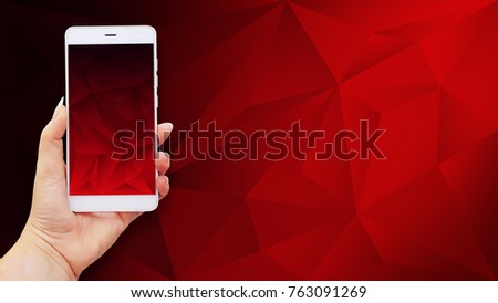 Mockup image of hands holding white mobile phone with red screen on polygonal background