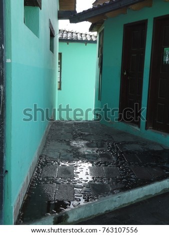 Beautiful corner street urban city vintage with turquoise color walls and a wet black floor. Colorful contrast photography