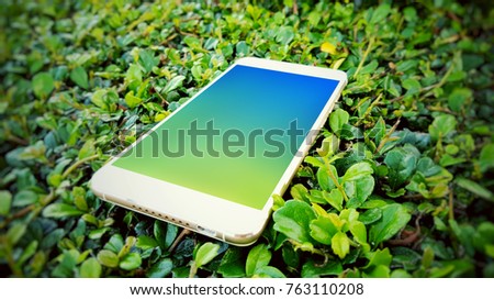 Mobile smart phone in green grass