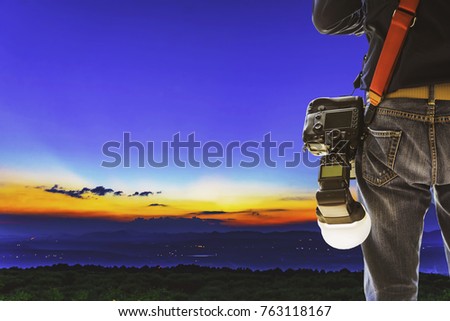 Close up of young man holding DSLR camera