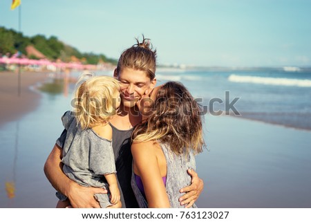 Family holiday near the sea. Father, mother and little daughter on beach.