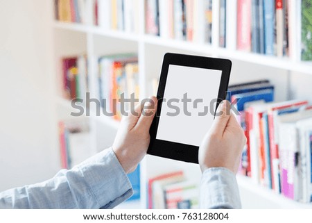 E-book reader in hands in a bookstore