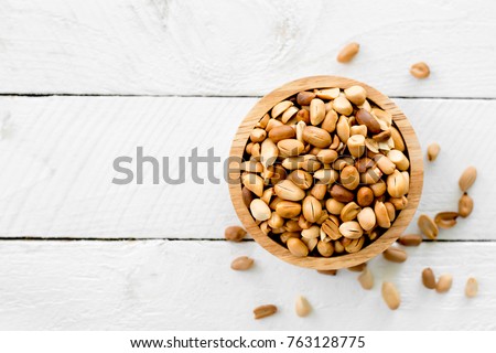 Roasted peanuts are placed on a white wooden floor. Royalty-Free Stock Photo #763128775