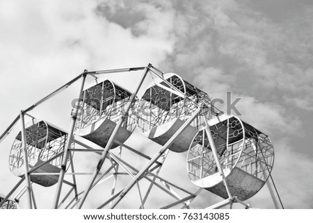 Retro Ferris wheel in park of Thailand with blue sky background. This image was blurred or selective focus. Black and white picture.