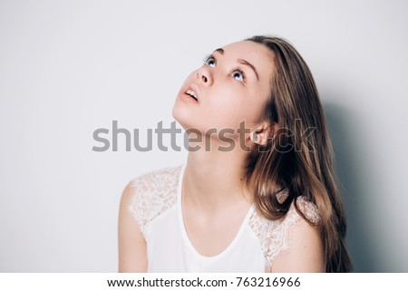 Young teenage girl looking up isolated on white background