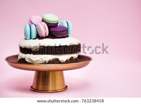 Small chocolate vanilla cake decorated with macaron cookies
