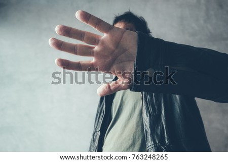Celebrity male hiding face with hands from paparazzi photographers, no photos gesture