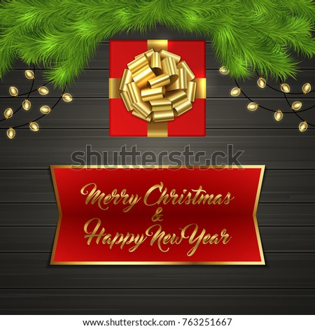 Christmas card with Cristmas fir tree branches, red square gift box with gold ribbon bow, garland on black wooden board. Greeting text Merry Chrismas and Happy New Year on red label with gold frame