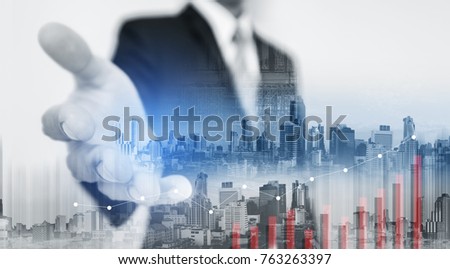 Double exposure Businessman extending hand with buildings in the city and raising graph Royalty-Free Stock Photo #763263397