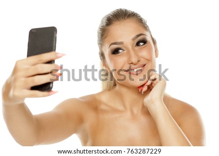 Young beautiful woman making selfies on white background