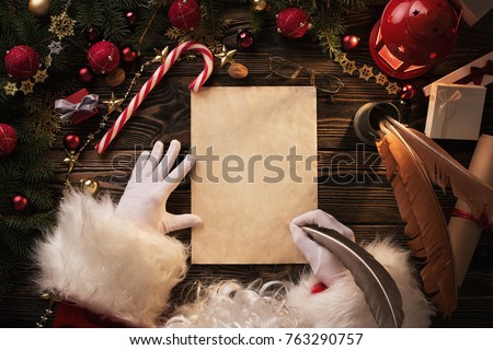 Close up of Santa Claus hands writing letter on Worden desk with copy space