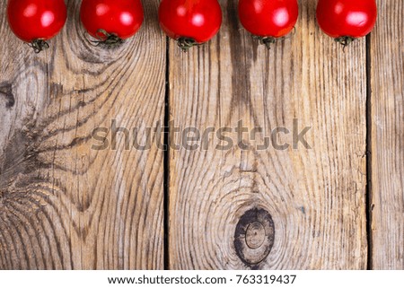 Small red tomatoes on wooden table. Studio Photo