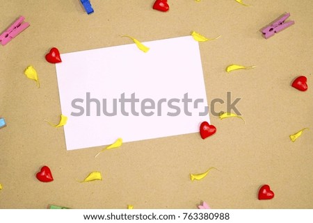 White paper note with mini red hearts, flowers , multicolor of wood clips. Flat lay. Copy space. Minimal style. Top view.