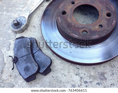 an old brake disk and wrenches on a concrete floor