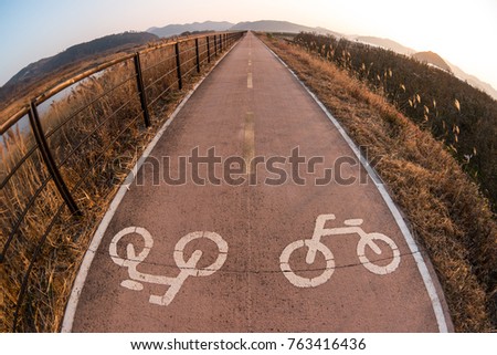 Symbol to indicate road for bicycles in nature before sunset