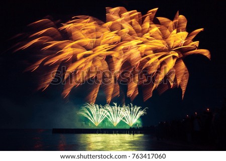 Festive, holiday fireworks of golden color on a black sky background. Very long shutter speed