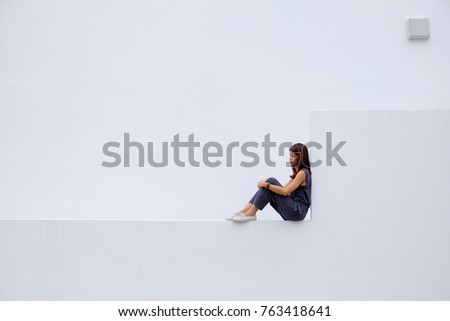 Asian woman wearing grey suit, white shoes and look forward to bright future on white wall background. Copy space.