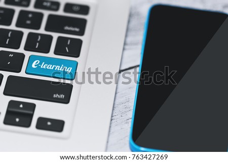 Remote education and e-learning idea using the laptop with internet conncetion an and a cell phone with mobile app. Replaced enter key with a tagline one. Selective focus, close-up capture.