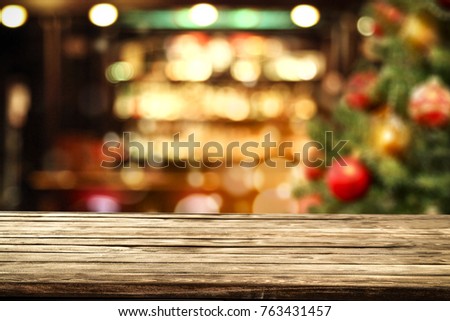 Desk of free space and christmas time background of x mas tree and blurred home interior 