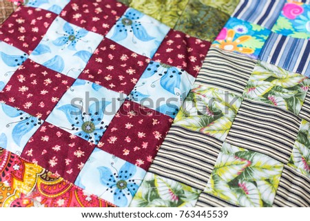 background, applied art, hobby, skill, perfection, handcraft, piecework, needlework concept - close-up of diverse fabric sewed of different textile scraps with various ornament Royalty-Free Stock Photo #763445539