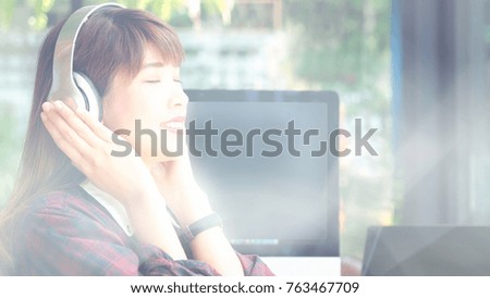 Blurred image, beautiful young woman designer listening music with headphone for inspiration ideas to working in office background