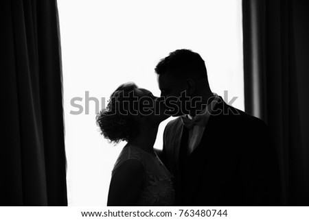 Silhouette of couple. Wedding persons - bride and groom kissing