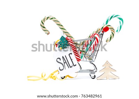 Image of trolley with caramel canes, Christmas tree, greeting card, ribbon