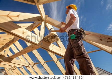  worker roofer builder working on roof structure on construction site Royalty-Free Stock Photo #763498480