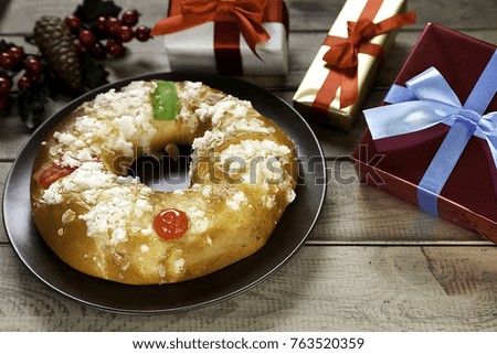 epiphany cake and Christmas presents with mistletoe and glasses of champagne on  wooden background