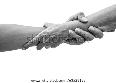 Dramatic black and white help hands holding together representing friendship, partnership, help and hope, donation, assistance.