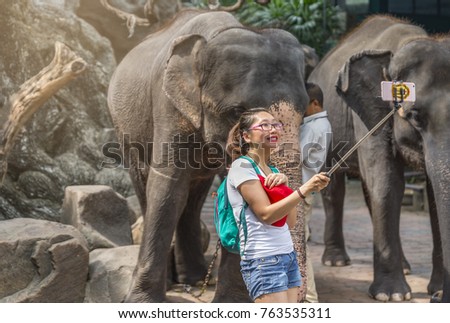 Bangkok, Thailand - Nov 19, 2017 Unidentified Asian ourist woman selfie with elephant at Safari World Zoo