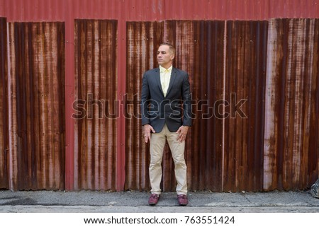 Portrait of handsome Persian businessman in the streets outdoors