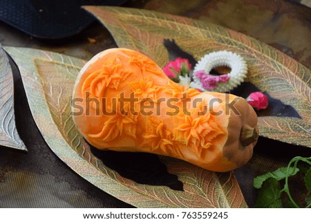 Decorated pumpkin on the wooden plate