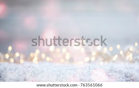 Ethereal soft Christmas background with a magical sparkling bokeh of party lights in a misty dreamy background over snow with copy space
