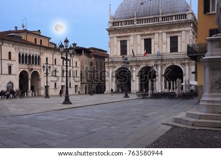 "Loggia" square in the evening with full moon. City Hall Palace of Brescia, Italy.