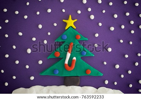 Christmas tree with ornaments and candy cane. Christmas tree, ornaments and snow are made out of play clay (plasticine).