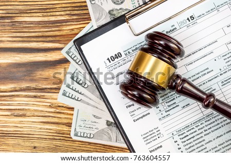 Judge's gavel on the tax form with money. Tax law. Top view. Royalty-Free Stock Photo #763604557
