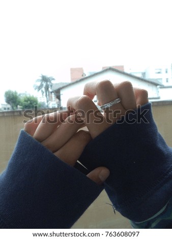 Vertical close up photography of a pair of girl woman hands against the window wearing a diamond ring