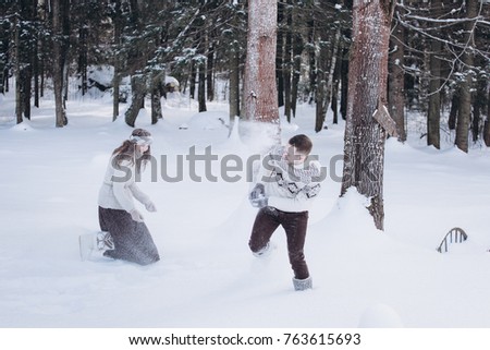 People, season, love and leisure concept - happy couple hugging and laughing outdoors in winter. Couple embracing and having fun in snowy winter park