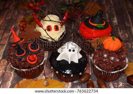 Set of homemade cupcake on Halloween  in the form of monsters  close-up in the decorations of the autumn interior.